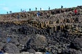 People climbing Giants Causeway and Cliffs, Northern Ireland