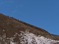 People climbing up a rocky hill on the hiking path to recently erupted volcano near Fagradalsfjall, Iceland.