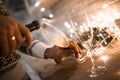 People clinking glasses of champagne against blurred background, closeup. Bokeh effect Royalty Free Stock Photo