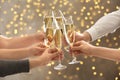 People clinking glasses with champagne against blurred lights. Bokeh effect Royalty Free Stock Photo