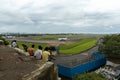 People from the close by neighboring slum watching airplanes taxing on runway of Mumbai International airport