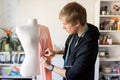 Fashion designer with dummy making dress at studio