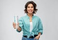 Smiling young woman holding water in glass bottle Royalty Free Stock Photo