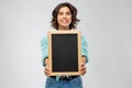 Portrait of smiling woman showing black chalkboard Royalty Free Stock Photo