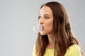 Young woman or teenage girl blowing bubble gum Royalty Free Stock Photo