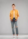 Red haired teenage girl in shirt and torn jeans Royalty Free Stock Photo