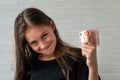 people concept - smiling teenage girl in pullover holding ten euros money banknotes over grey background Royalty Free Stock Photo