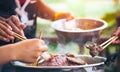 People cooking meat and grill. Food are vegeteble. People use chopsticks.