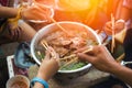 People cooking meat and grill. Food are vegeteble. People use chopsticks.