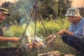 People cooking outdoors barbecue on fire in summer camp