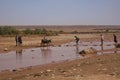 People cross the river Asif Ounila near the Kasbah Ait Ben Haddou  in the Atlas Mountains, Morocco. Royalty Free Stock Photo