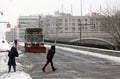 People cross street as NYC Sanitation truck plows snow in the Br