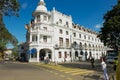 People cross street in front of the historical building of the Queen`s hotel in Kandy, Sri Lanka. Royalty Free Stock Photo