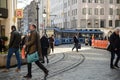 People cross the street in front of a street car