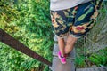 People crossing Capilano Cliff Walk Suspension Bridge in Vancouver, detail on tourists legs, downward view