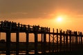 People crossing the longest teak bridge in the world, the iconic wooden U Bein Bridge during sunset, Mandalay, Myanmar Royalty Free Stock Photo