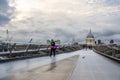 People crossing the Millennium Bridge on a Cloudy Day Royalty Free Stock Photo