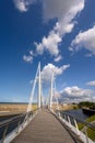 People crossing the Passerelle du Grand Large - Large Bridge - in Dunkirk on a sunny day with fluffy white clouds in a deep blue