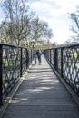 People crossing the river cam at an old iron pedestrian bridge