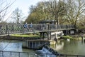 People crossing the river cam at an old iron pedestrian bridge