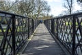 People crossing the river cam at an old iron pedestrian bridge