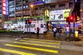 People crossing street in front of transport in Hong Kong