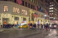 People are Crossing the Street Outside a Store in Manhattan, New York City. Christmas Decoration with Bright Lights at Night Royalty Free Stock Photo