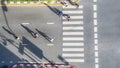 People crowd walk in top view at street city with pedestrian crosswalk in traffic road with light and shadow silhouette Royalty Free Stock Photo