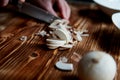 People cut mushrooms with a knife.The slices are adjacent. Wooden surface