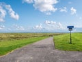 People cycling on bicycle path between dike and salt marshes on Frisian island Schiermonnikoog, Netherlands