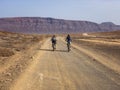 People cycling on a dirt path in the island of La Graciosa, Lanzarote, Canary Islands