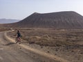 People cycling on a dirt path in the island of La Graciosa, Lanzarote, Canary Islands