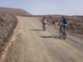 People cycling on a dirt path in the island of La Graciosa, Lanzarote, Canary Islands