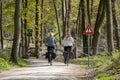 People cycling through forest near Laarder Wasmeer, Goois Nature Reserve, Hilversum, Netherlands