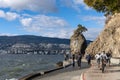 People cycling in Stanley Park Seawall Siwash Rock in sunny day.