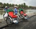 People with cyclos waiting on street in Hoi an, Vietnam