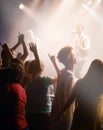 People dancing, concert and singing music at night performance, gen z band singer with lights and cheers. Musician on Royalty Free Stock Photo