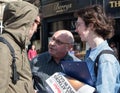 People debating politics on the street. One person holding a copy of Socialist Worker