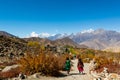 People descending down a dirt path to Muktinath.