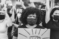 People from different culture and races protest on the street for equal rights with safety masks - Focus african woman