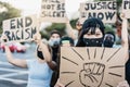 People from different culture and races protest on the street for equal rights wearing protective masks - Focus on asian girl