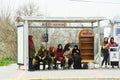 People of different ethnic groups are waiting for a bus