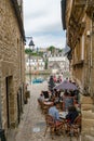 People dining out in a picturesque French restaurant in a narrow street