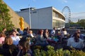 People dining outside the Royal Festival Hall in with London Eye Royalty Free Stock Photo