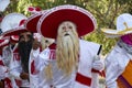 People disguised as a Mexican charro or mariachi with a white suit and masks