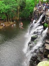 People diving from waterfall top