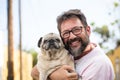 People and dogs love concept - Funny and happy portrait of young handsome adult man and best friend forever together dog pug both Royalty Free Stock Photo