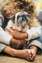 People dogs owner and best friends love concept - woman embrace her pug at home sitting on the floor - puppy protection and Royalty Free Stock Photo