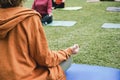 People doing yoga class outdoor sitting on grass - Social distance and sport concept - Main focus on man hand Royalty Free Stock Photo