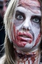 People dressed as a zombie parades on a street during a zombie walk in Paris.